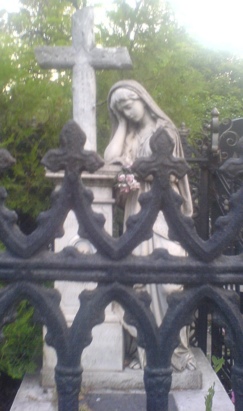Как поминать усопших, статуя девы Марии на кладбище.